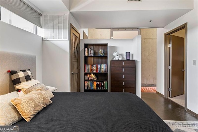 bedroom with a closet and concrete floors