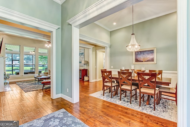 dining room featuring ceiling fan with notable chandelier, crown molding, and hardwood / wood-style floors