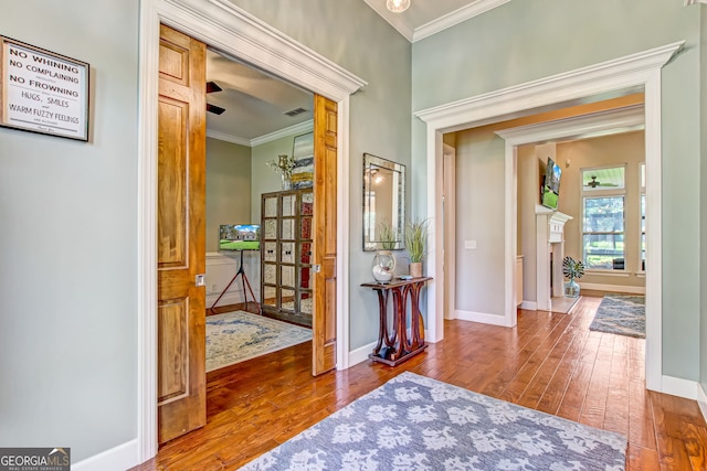 foyer entrance featuring hardwood / wood-style flooring and crown molding