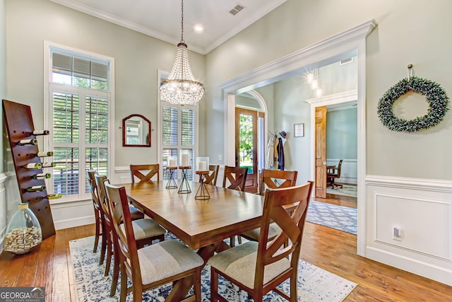 dining area featuring crown molding, light hardwood / wood-style flooring, and a wealth of natural light