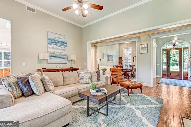 living room featuring ornamental molding, ceiling fan, and light hardwood / wood-style floors