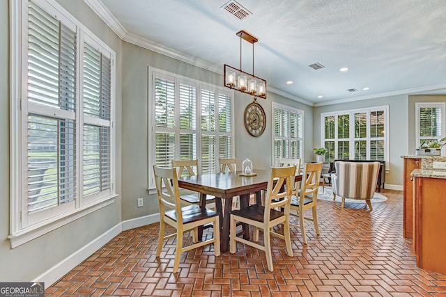 dining area with ornamental molding, an inviting chandelier, and a textured ceiling