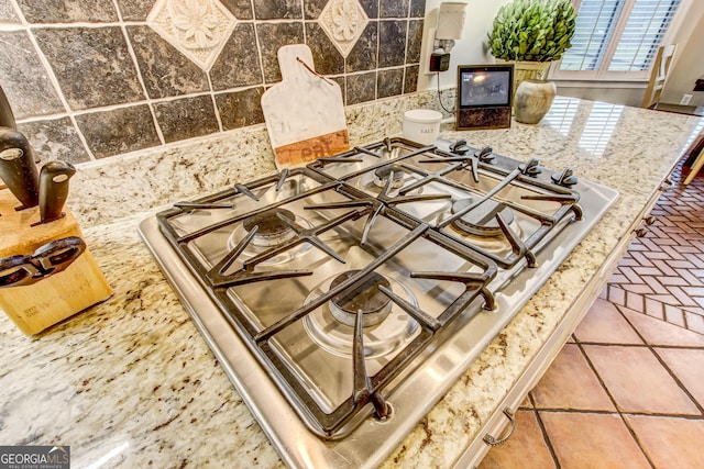 interior details featuring tile patterned flooring, stainless steel gas cooktop, and stone counters