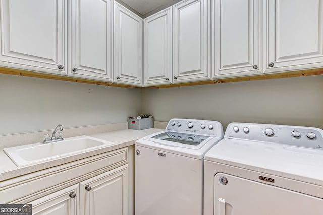 laundry area featuring washer and dryer, cabinets, and sink