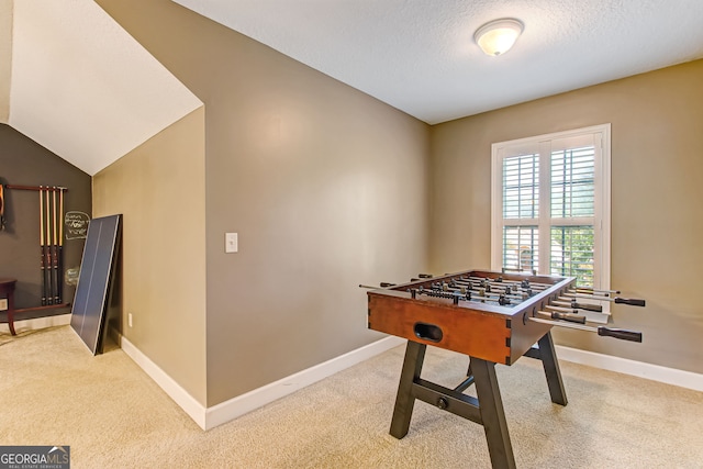 game room featuring lofted ceiling, carpet flooring, and a textured ceiling