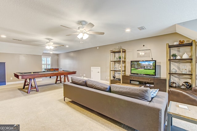 living room with light carpet, ceiling fan, and a textured ceiling