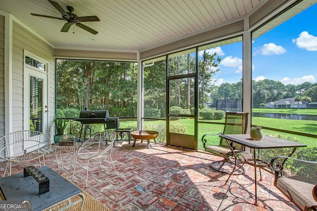 sunroom with a water view, ceiling fan, and wood ceiling