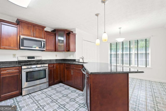 kitchen featuring pendant lighting, appliances with stainless steel finishes, sink, and a textured ceiling