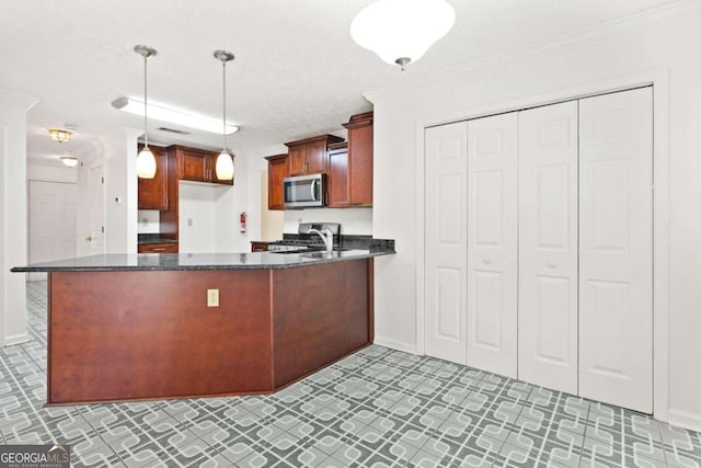 kitchen with pendant lighting, dark stone counters, kitchen peninsula, ornamental molding, and appliances with stainless steel finishes