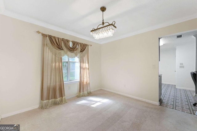 spare room with ornamental molding, carpet flooring, and a chandelier