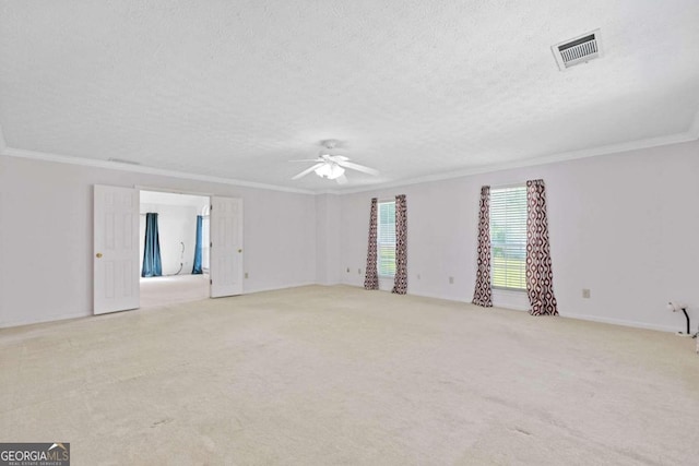 carpeted empty room with ornamental molding, ceiling fan, and a textured ceiling