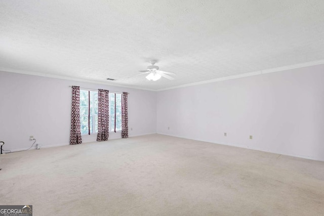 carpeted empty room featuring ceiling fan, a textured ceiling, and crown molding