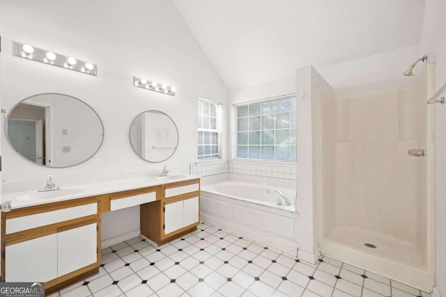 bathroom featuring vanity, vaulted ceiling, and independent shower and bath