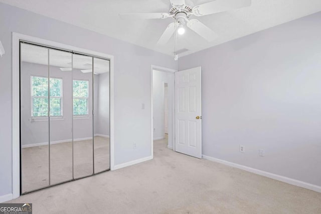 unfurnished bedroom with ceiling fan, a closet, and light colored carpet