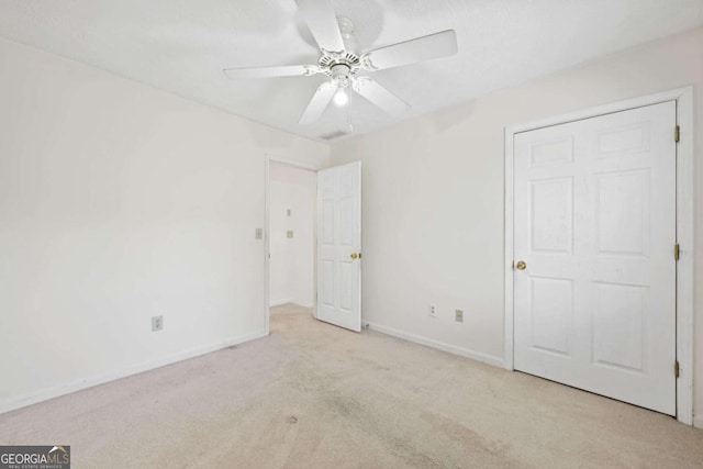 unfurnished bedroom with ceiling fan and light colored carpet