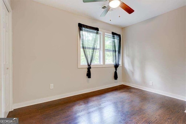 unfurnished room featuring dark wood-type flooring and ceiling fan