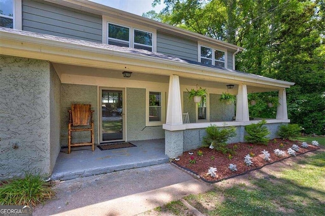 property entrance featuring stucco siding and a porch