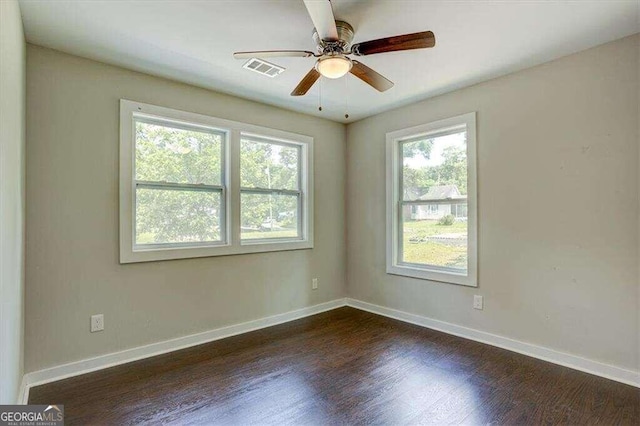 unfurnished room featuring baseboards, visible vents, a ceiling fan, and dark wood-type flooring