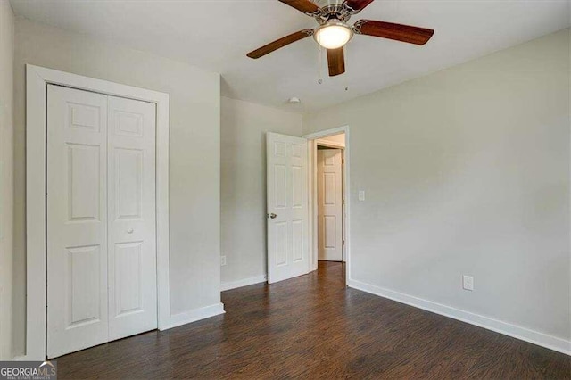 unfurnished bedroom featuring a closet, dark wood-style flooring, ceiling fan, and baseboards