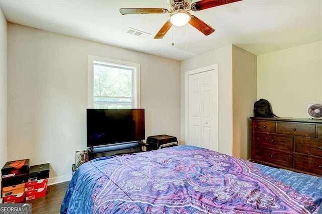 bedroom featuring a closet, a ceiling fan, visible vents, baseboards, and wood finished floors