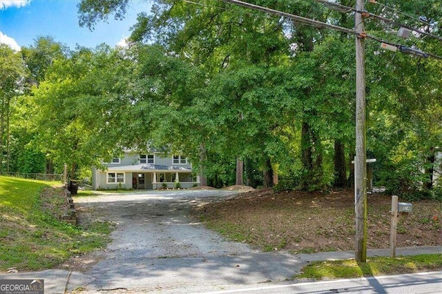 obstructed view of property featuring gravel driveway