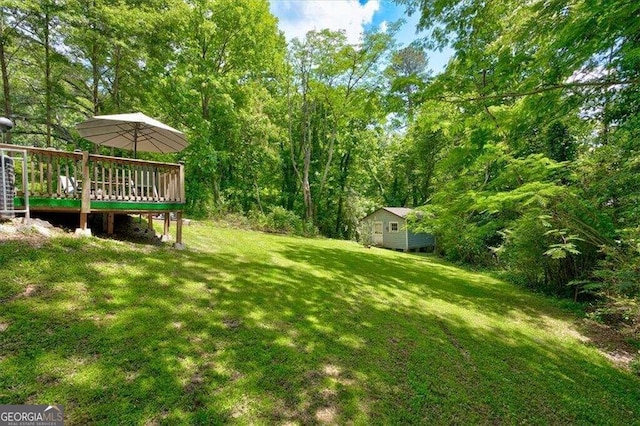 view of yard featuring a deck and a storage unit