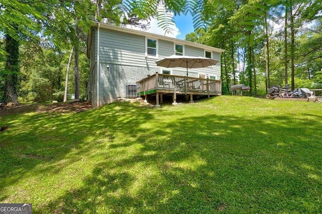 rear view of house featuring a deck and a lawn