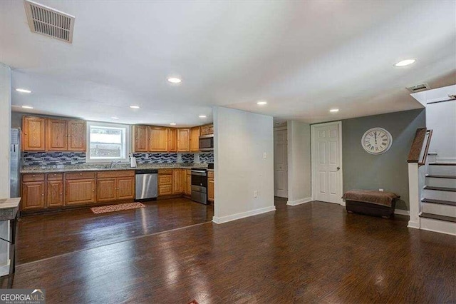 kitchen with appliances with stainless steel finishes, dark wood-type flooring, sink, and backsplash