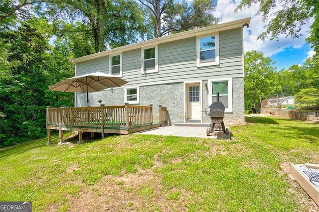 back of property featuring a patio, a deck, and a lawn