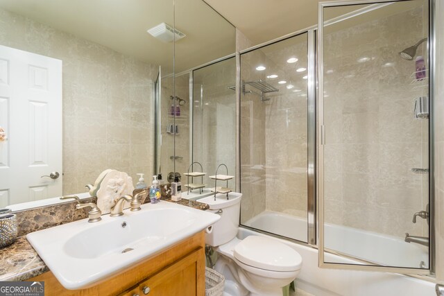 full bathroom featuring vanity, toilet, and combined bath / shower with glass door