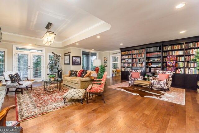 living room with wood-type flooring, french doors, and crown molding