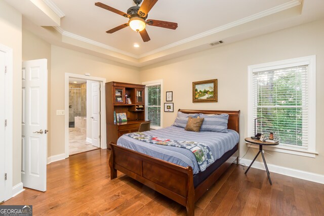 bedroom with wood-type flooring, ensuite bath, ceiling fan, and crown molding