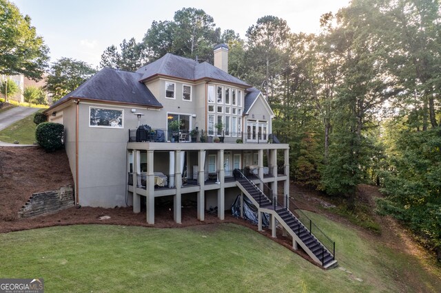 back of house with a deck and a yard