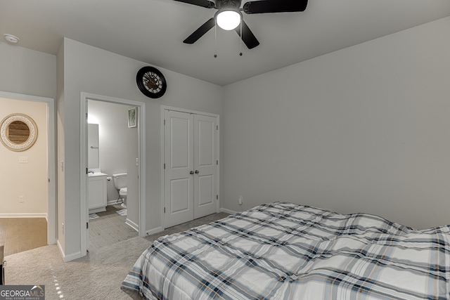 bedroom with ceiling fan, a closet, connected bathroom, and light colored carpet