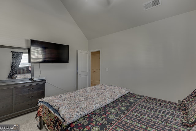 carpeted bedroom with high vaulted ceiling