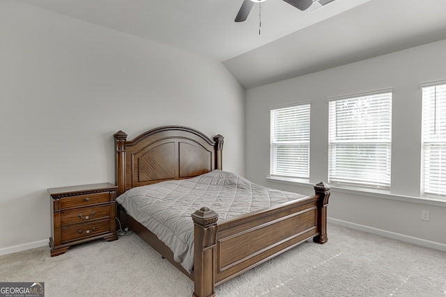 bedroom with multiple windows, ceiling fan, vaulted ceiling, and light colored carpet