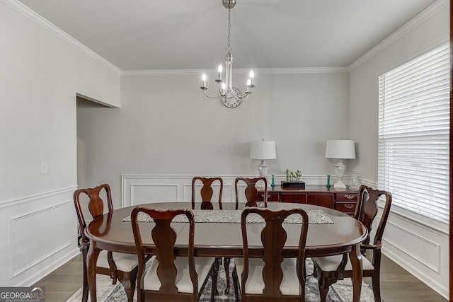 dining room with ornamental molding, a notable chandelier, and dark wood-type flooring