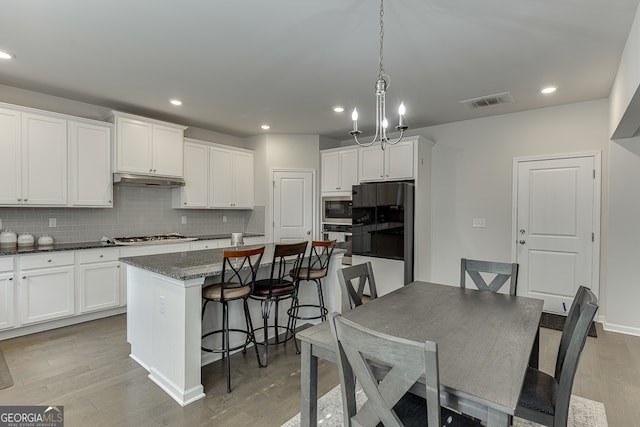 kitchen featuring a kitchen island, a kitchen bar, and light hardwood / wood-style flooring