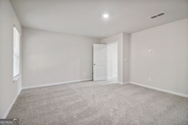 spare room featuring light carpet