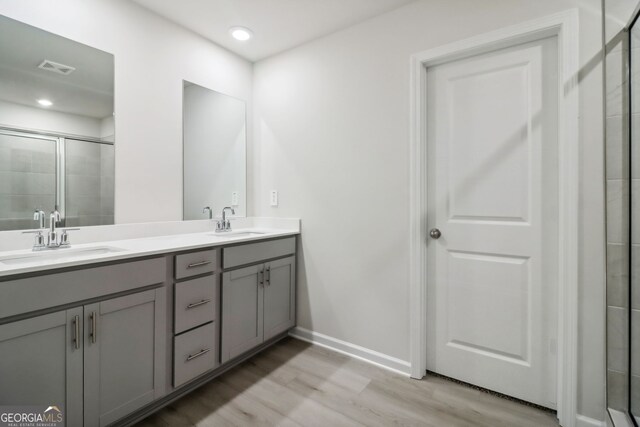 bathroom featuring vanity, hardwood / wood-style flooring, and an enclosed shower