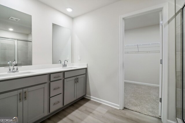 bathroom featuring vanity, hardwood / wood-style flooring, and a shower with shower door