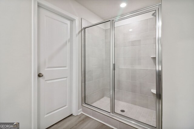 bathroom featuring hardwood / wood-style flooring and walk in shower