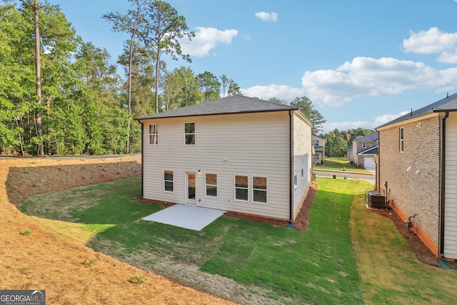 rear view of house featuring a patio, a yard, and central air condition unit