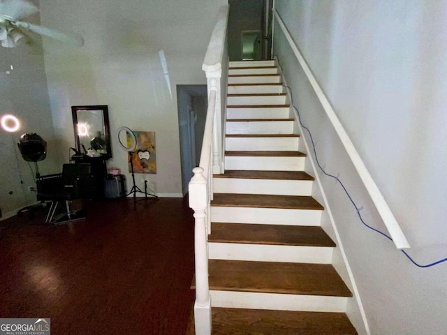 stairway with hardwood / wood-style floors and ceiling fan