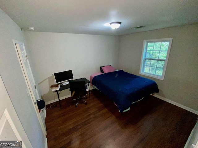 bedroom with dark hardwood / wood-style floors