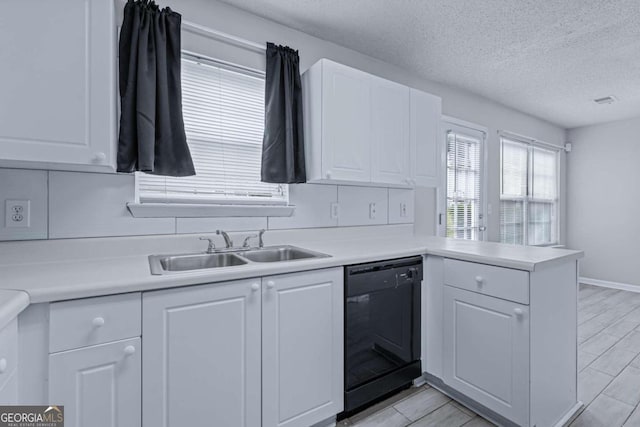 kitchen featuring sink, kitchen peninsula, light hardwood / wood-style flooring, white cabinetry, and black dishwasher