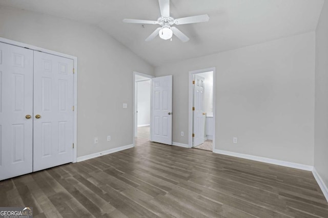 unfurnished bedroom featuring ceiling fan, a closet, vaulted ceiling, and dark hardwood / wood-style flooring