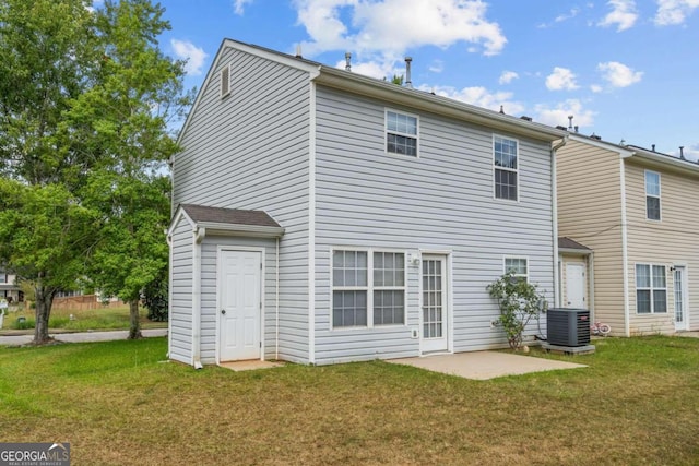 rear view of house with cooling unit, a lawn, and a patio area