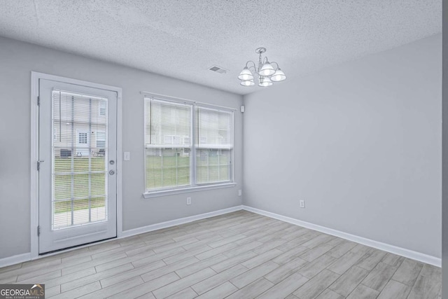 unfurnished dining area featuring a wealth of natural light, light hardwood / wood-style floors, and a textured ceiling