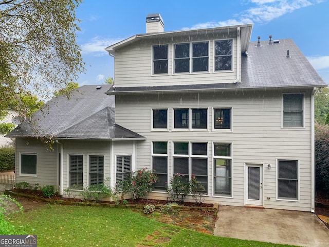 back of property featuring a yard and a patio area